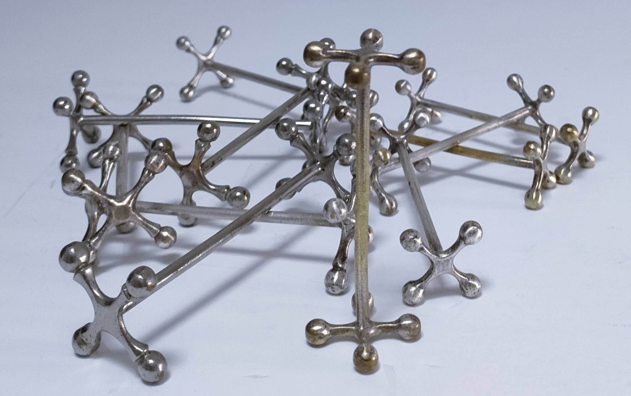 Eleven 70s design metal "crosshair" knife holders