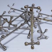 Eleven 70s design metal "crosshair" knife holders