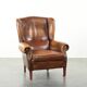Wingback armchair made of sheepskin leather finished with decorative nails