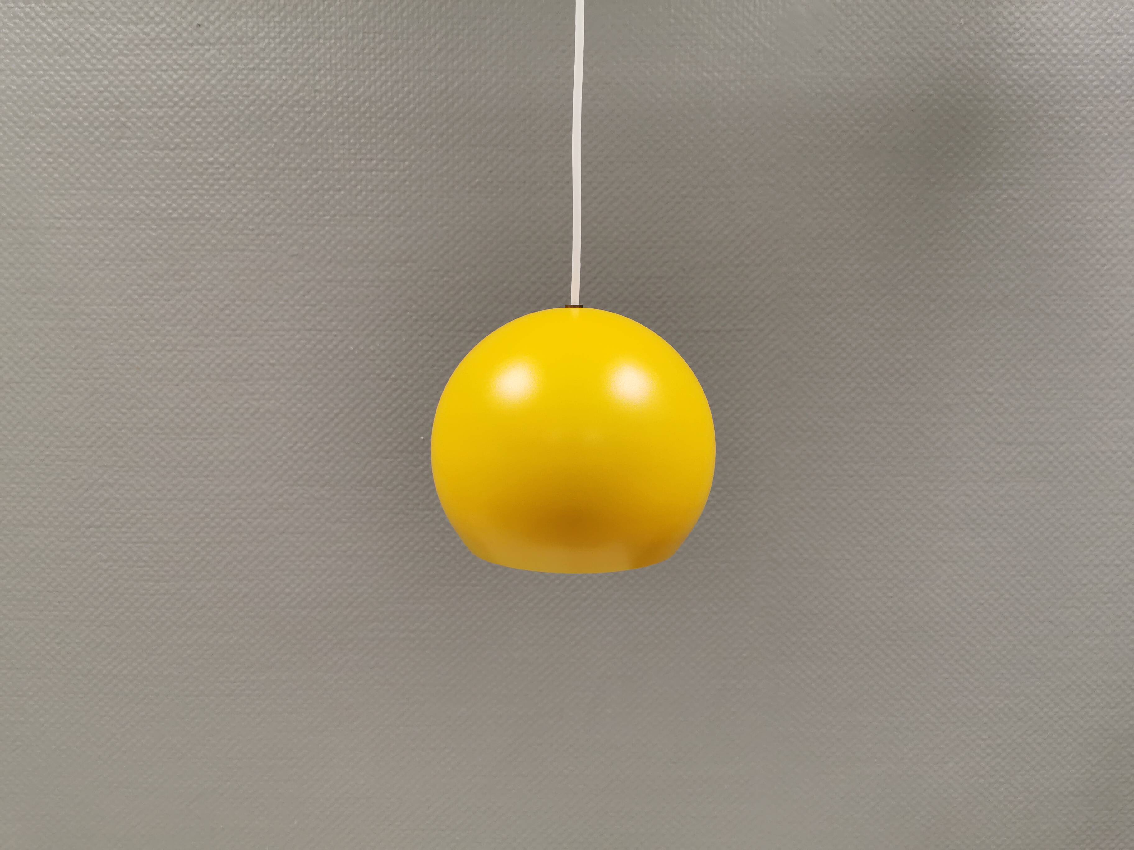 Spherical pendant lamp in sunny yellow.