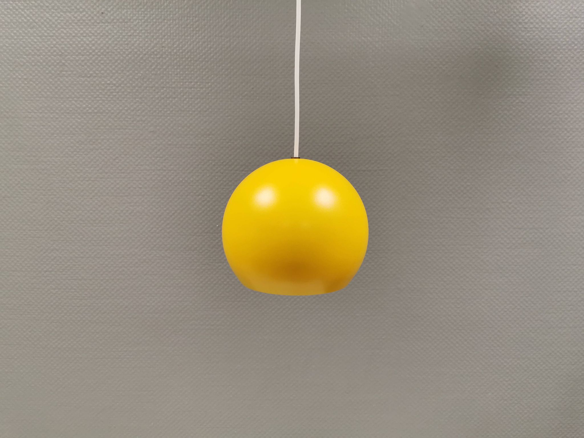 Lampe suspendue sphérique en jaune ensoleillé.