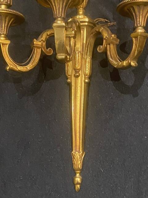 Pair of gilt bronze wall sconces with three lights in the Louis XVI style.