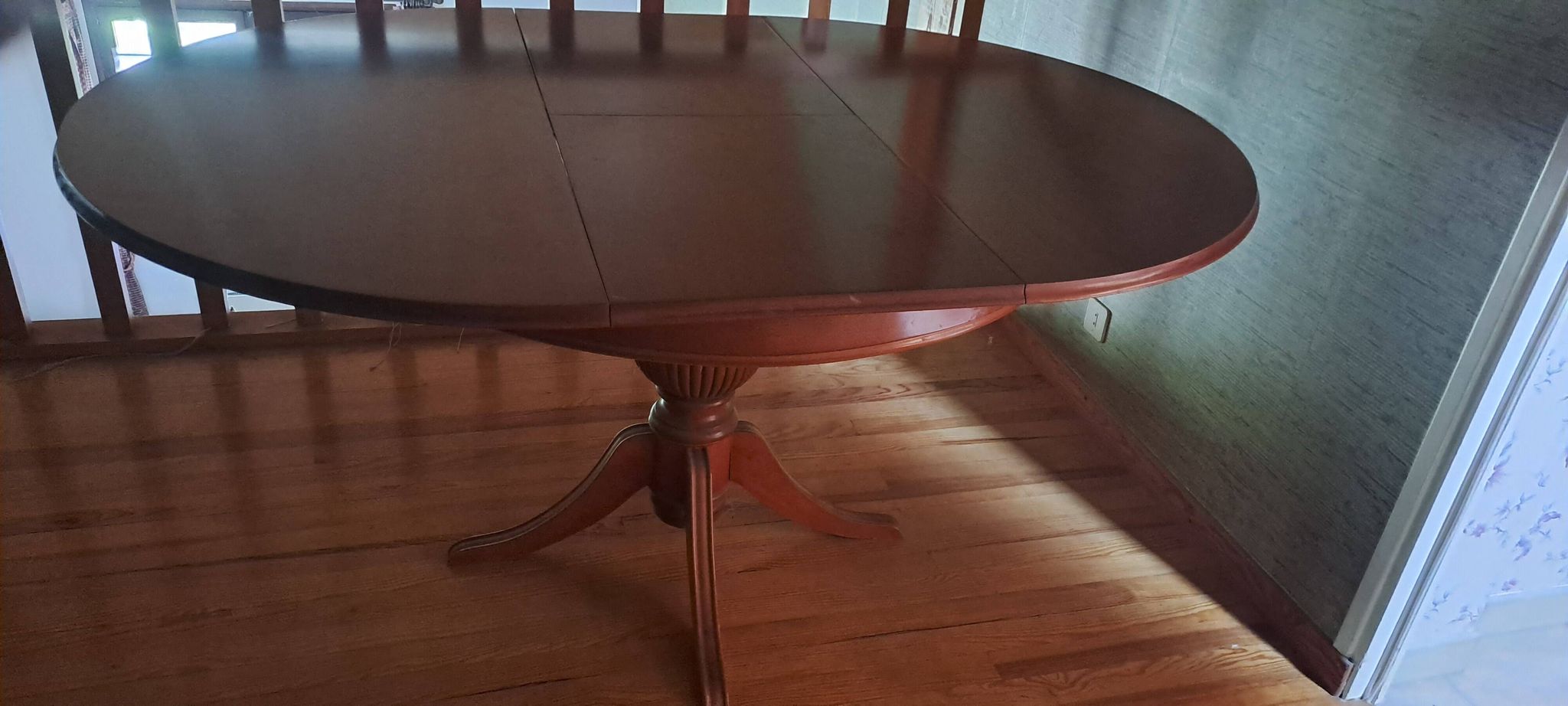 Round solid walnut table with central leg from the 1950s with extensions.