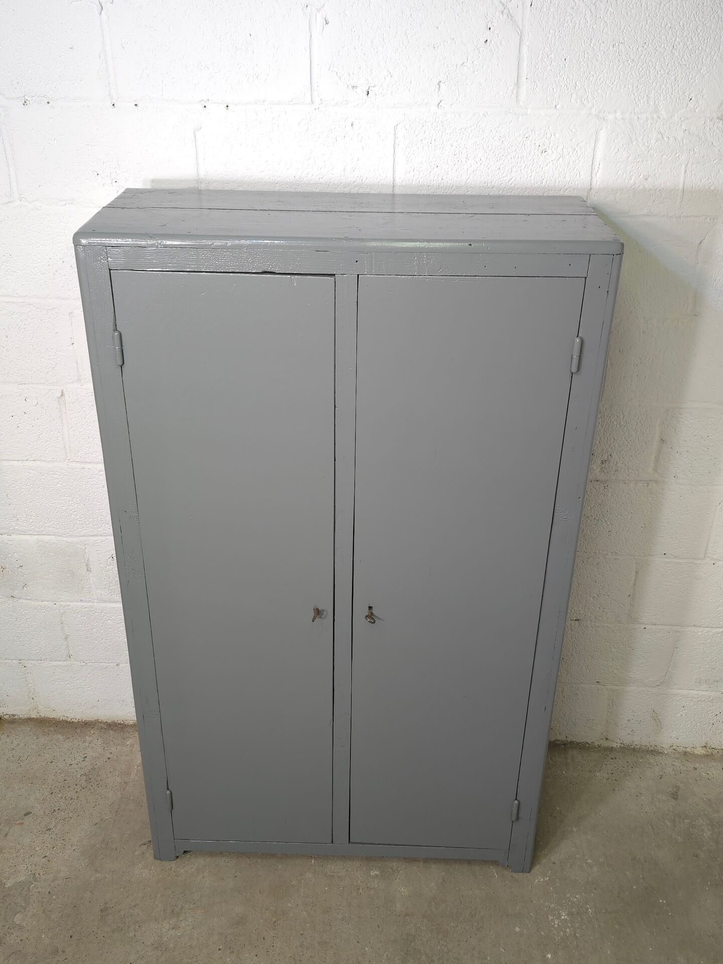 Curved wardrobe workshop locker made of wood repainted in grey.