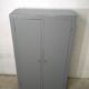 Curved wardrobe workshop locker made of wood repainted in grey.
