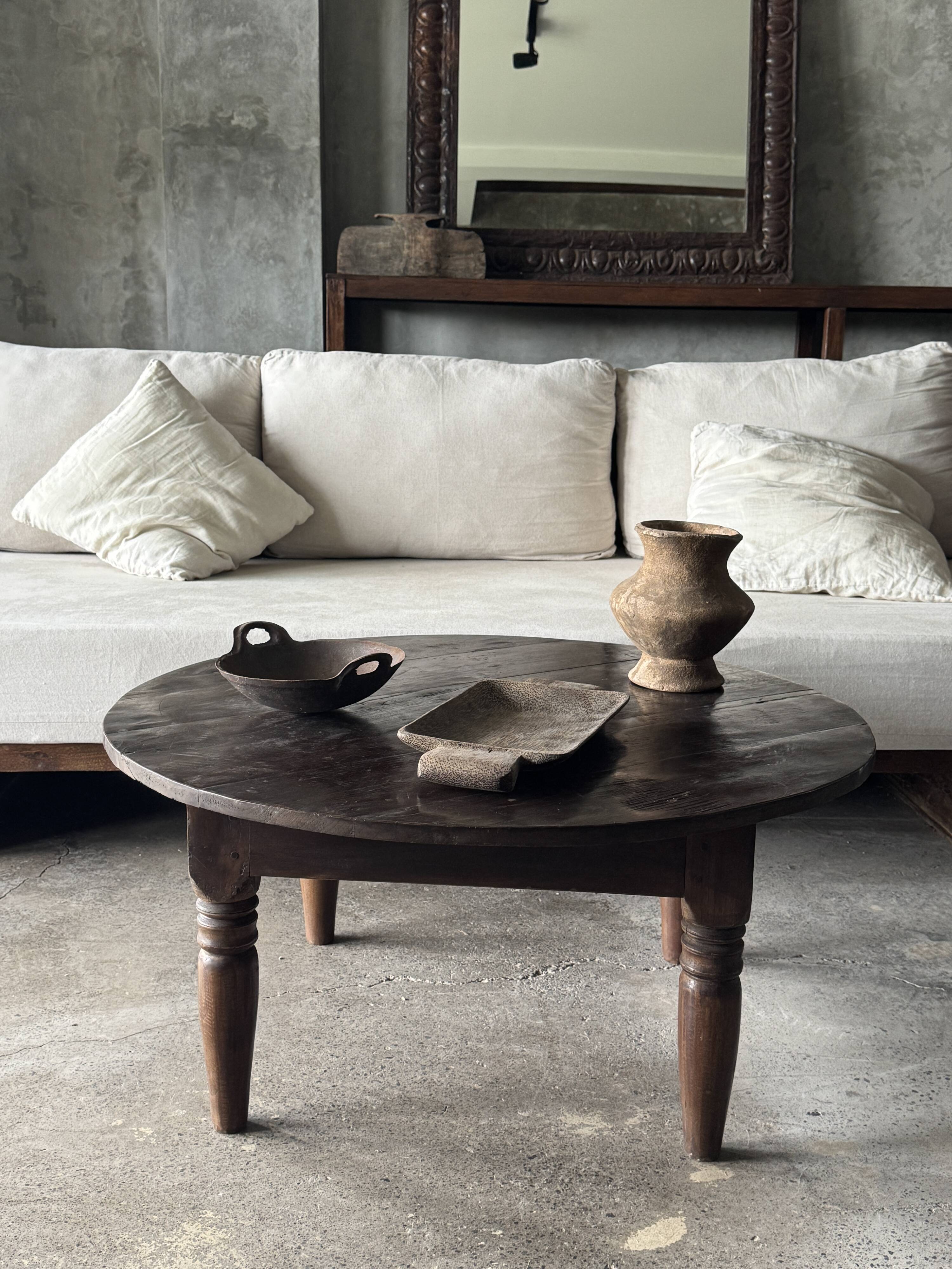 Coffee table, round antique Indonesian teak table with straight legs.