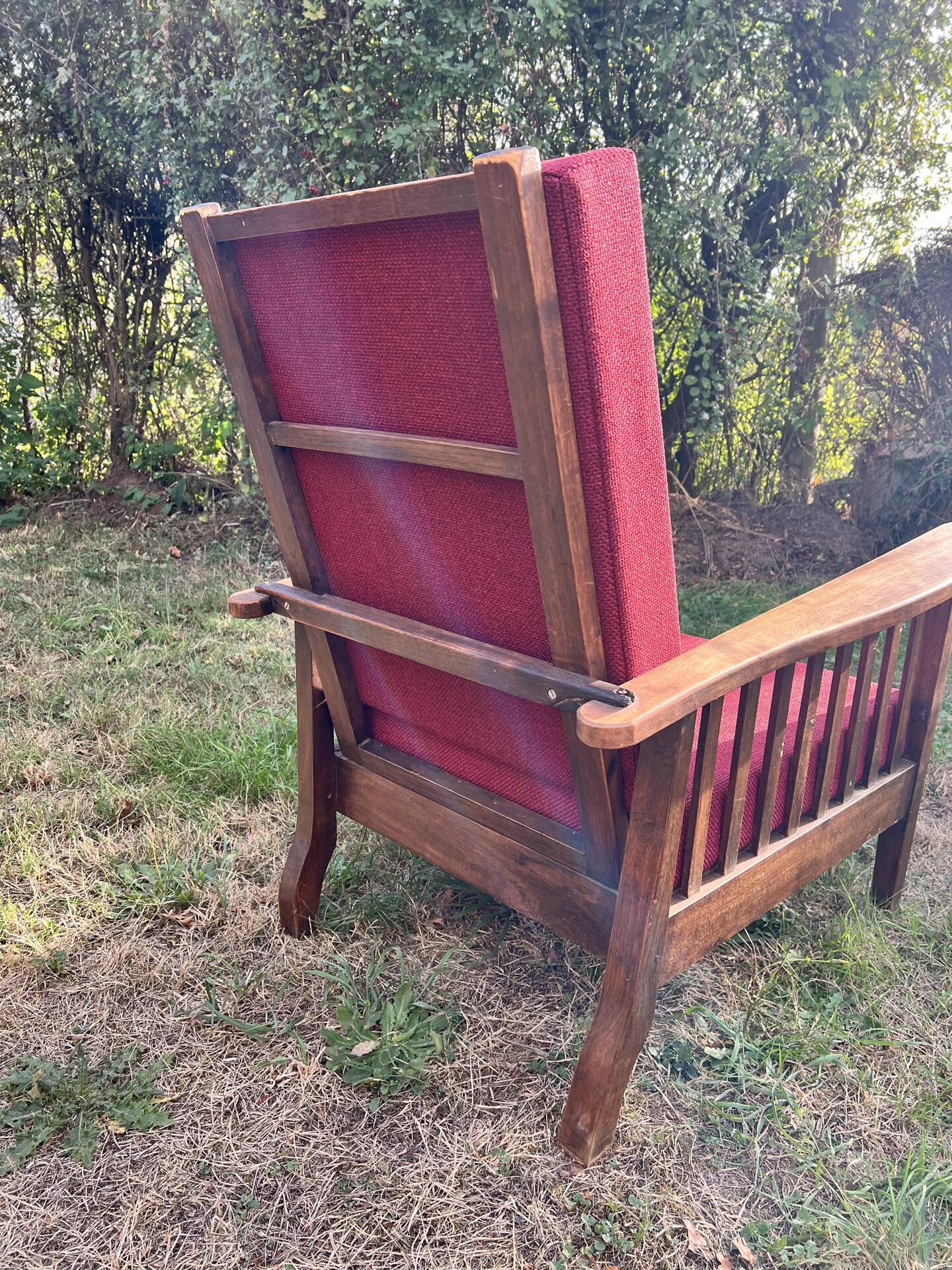 Morris chair with wooden frame and burgundy cushions.