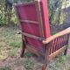 Morris chair with wooden frame and burgundy cushions.