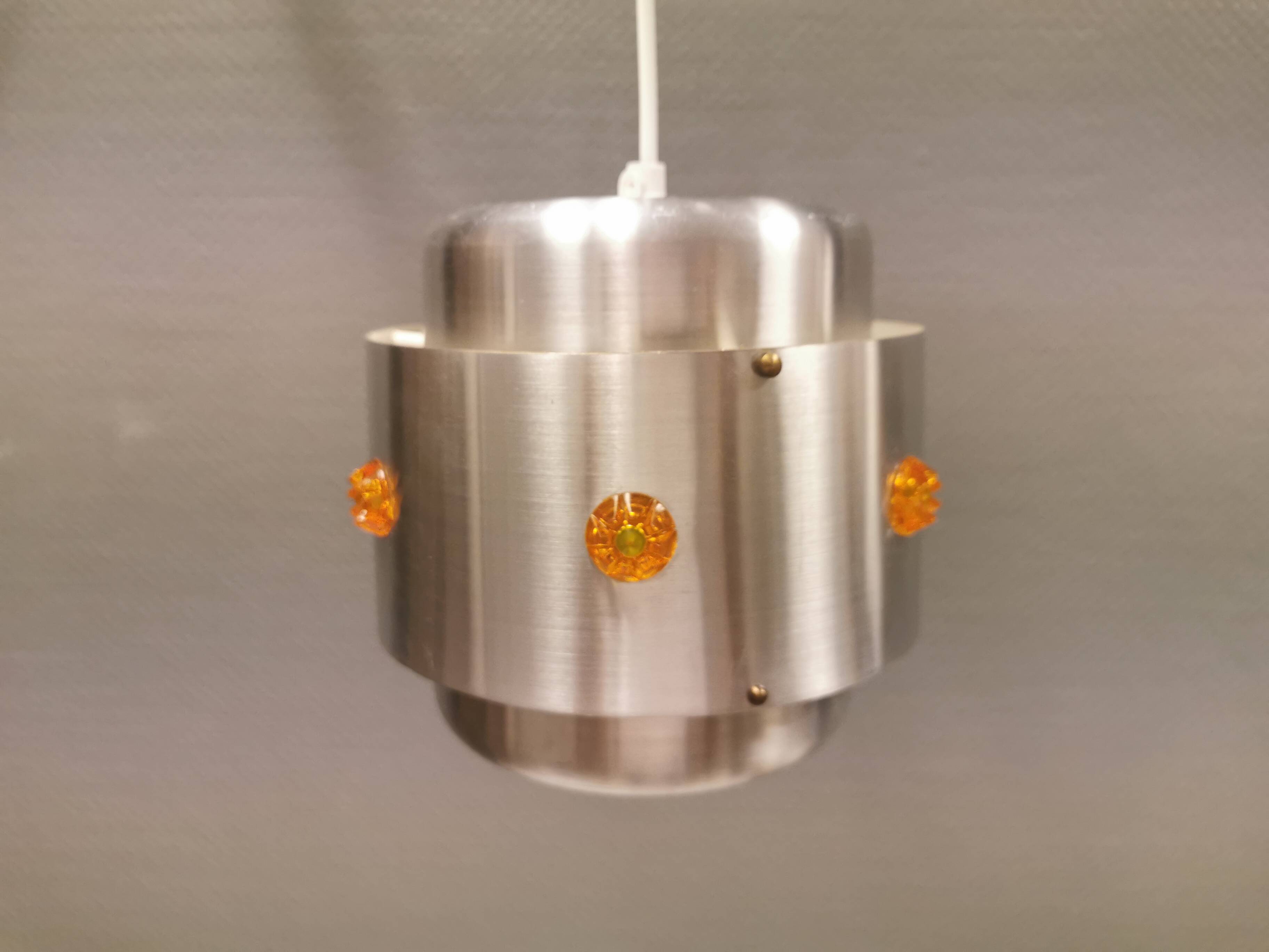 Two Space-Age hanging lamps, in silver-coloured aluminium with orange prisms.