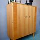 Vintage 1960s shoe cabinet in light wood and chrome metal.