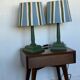 Pair of vintage wooden lamps with their striped beige, blue, and green shades.