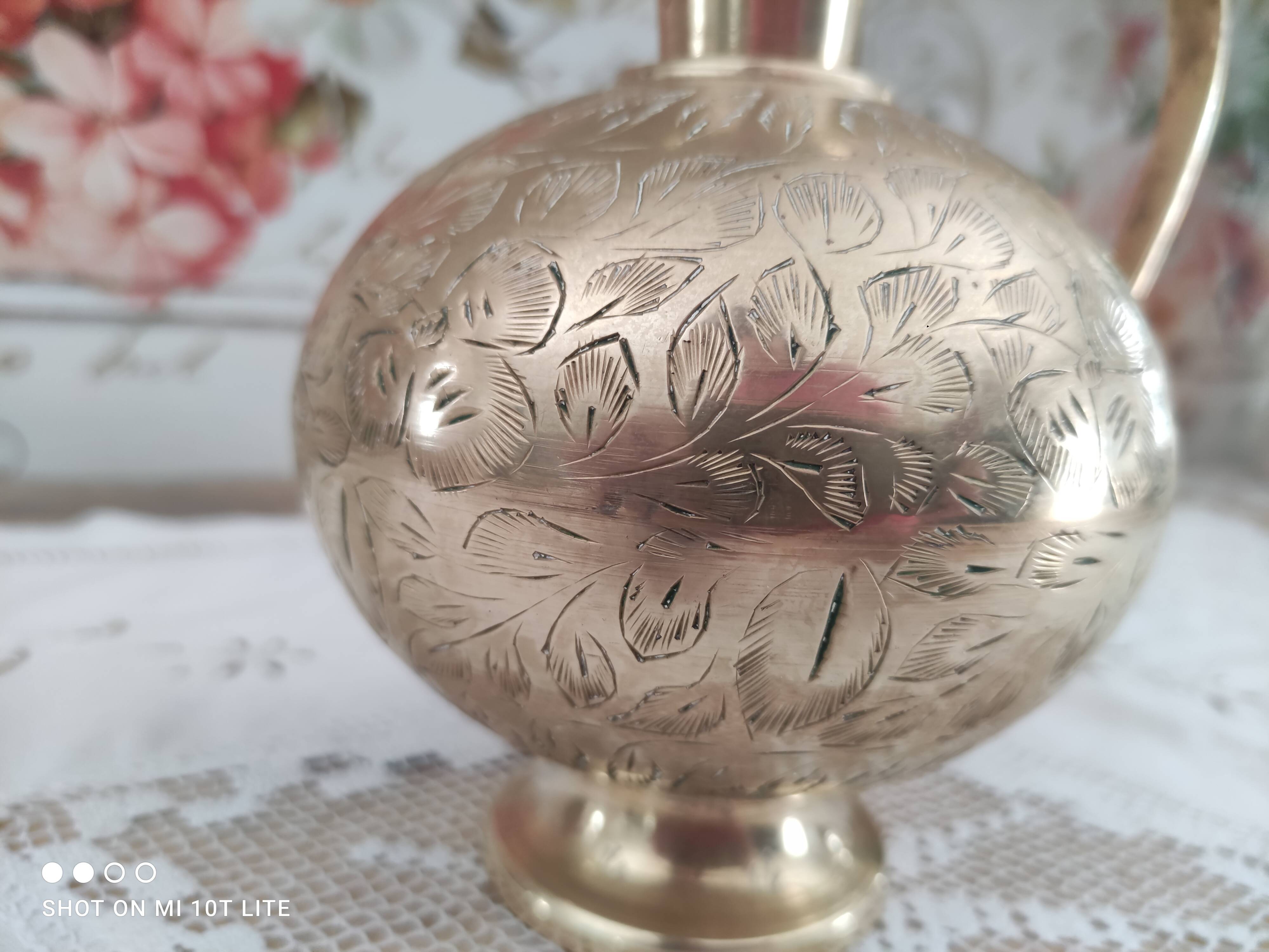 Chiseled brass pitcher decorated foliage