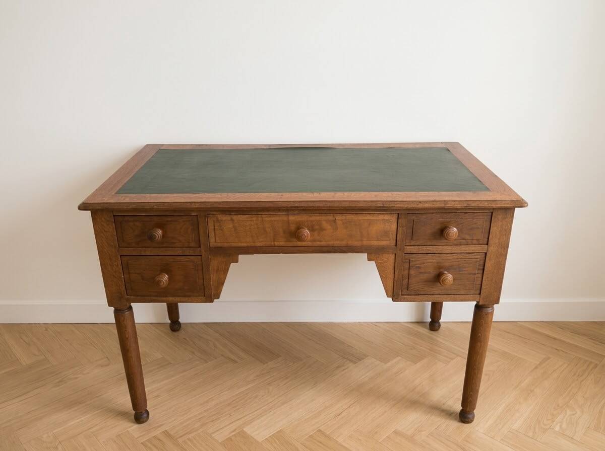 Antique wooden desk with a sloped top and green writing pad.