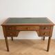 Antique wooden desk with a sloped top and green writing pad.