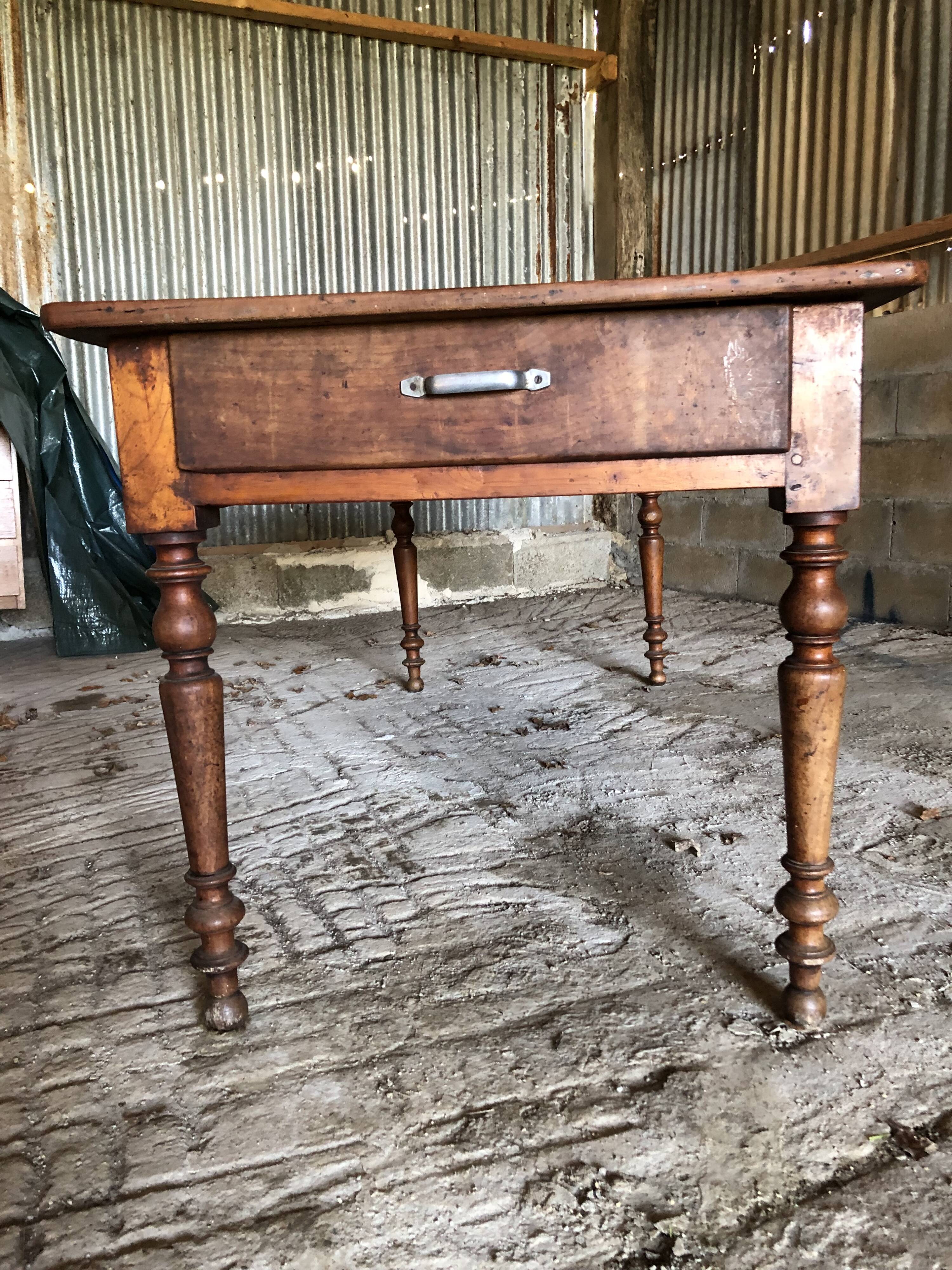 Antique Louis Philippe style farm table in solid cherry wood with turned base.