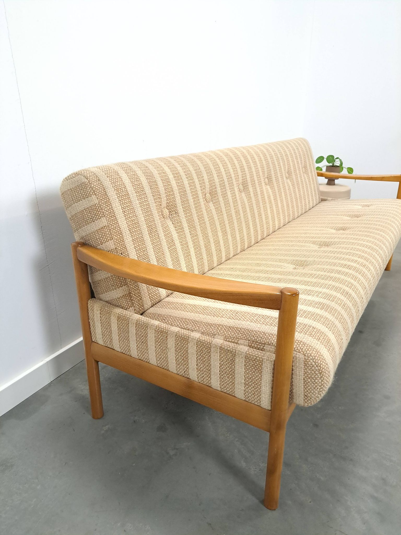 Canapé-lit beige rayé avec cadre en bois