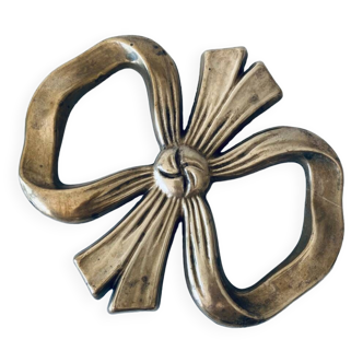 Bow-shaped brass trivet