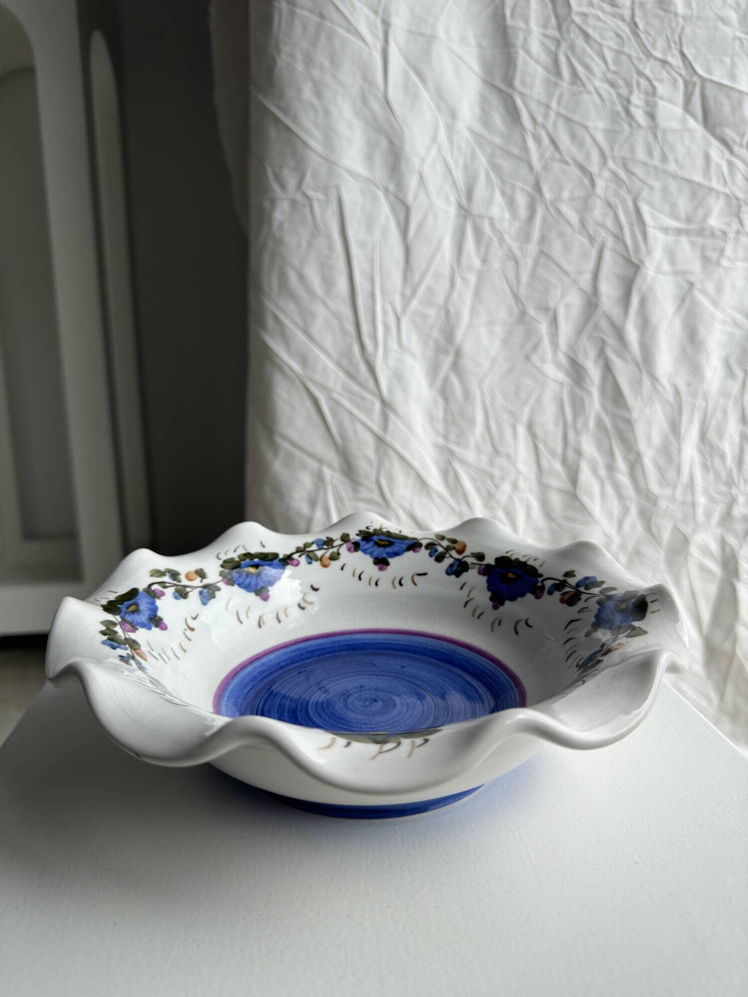 Small hand-painted earthenware salad bowl with garland of blue flowers, mark below
