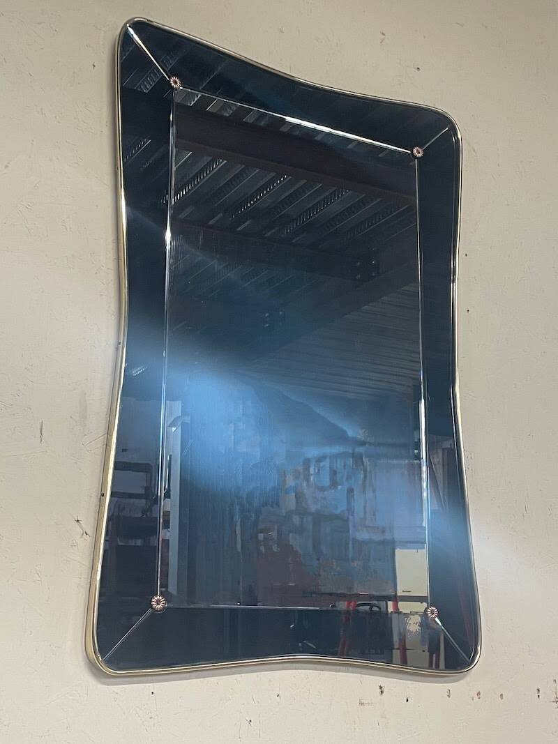 1950s double-thickness wall mirror with brass profile and supports.