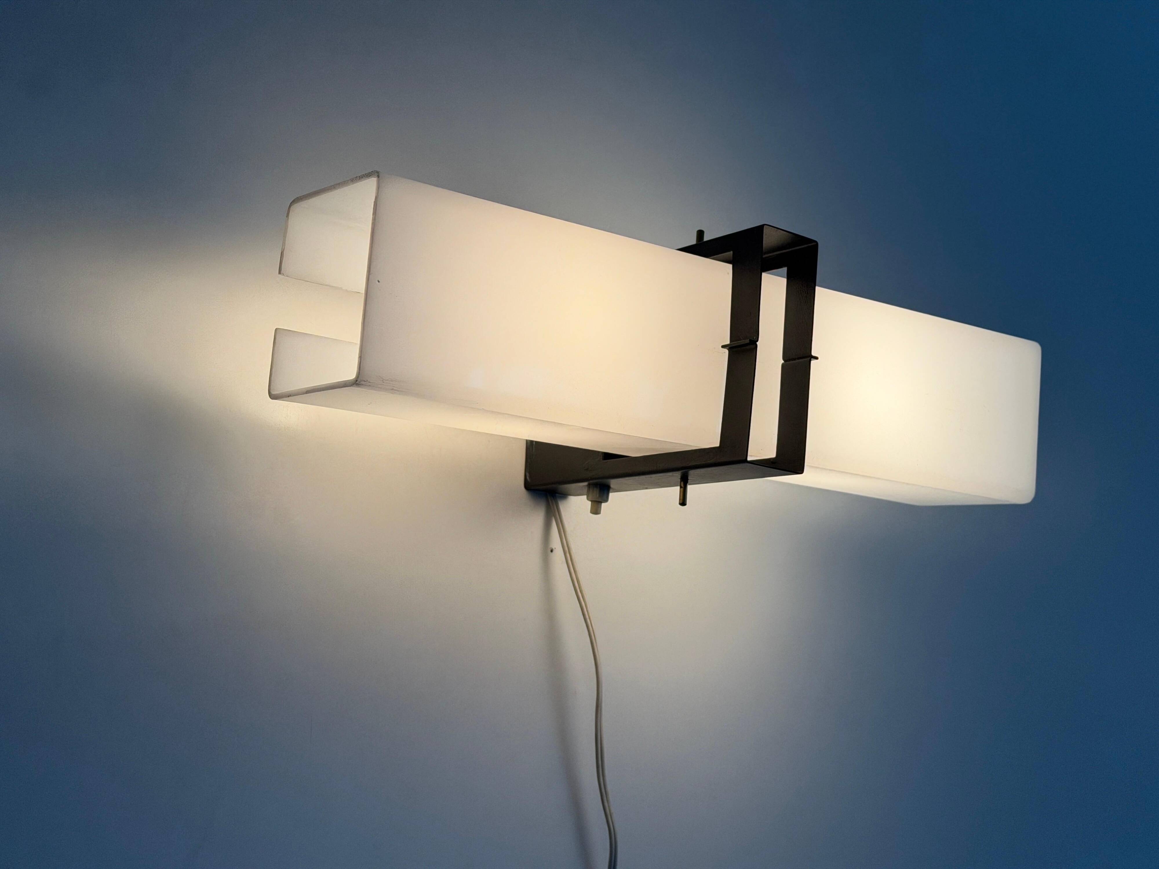 Simple white plexiglass wall light with a black metal frame, 1970s, Germany.