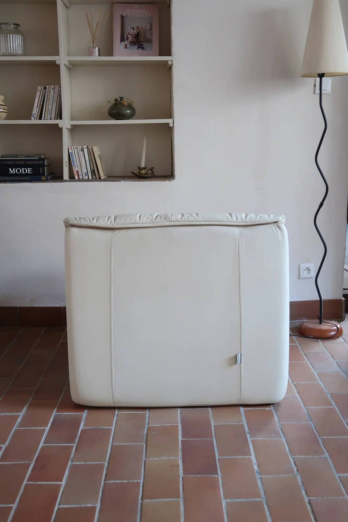 Cinna armchair in cream leather, bolstered armrests, 1970s.