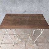 Wrought iron table with a walnut top.
