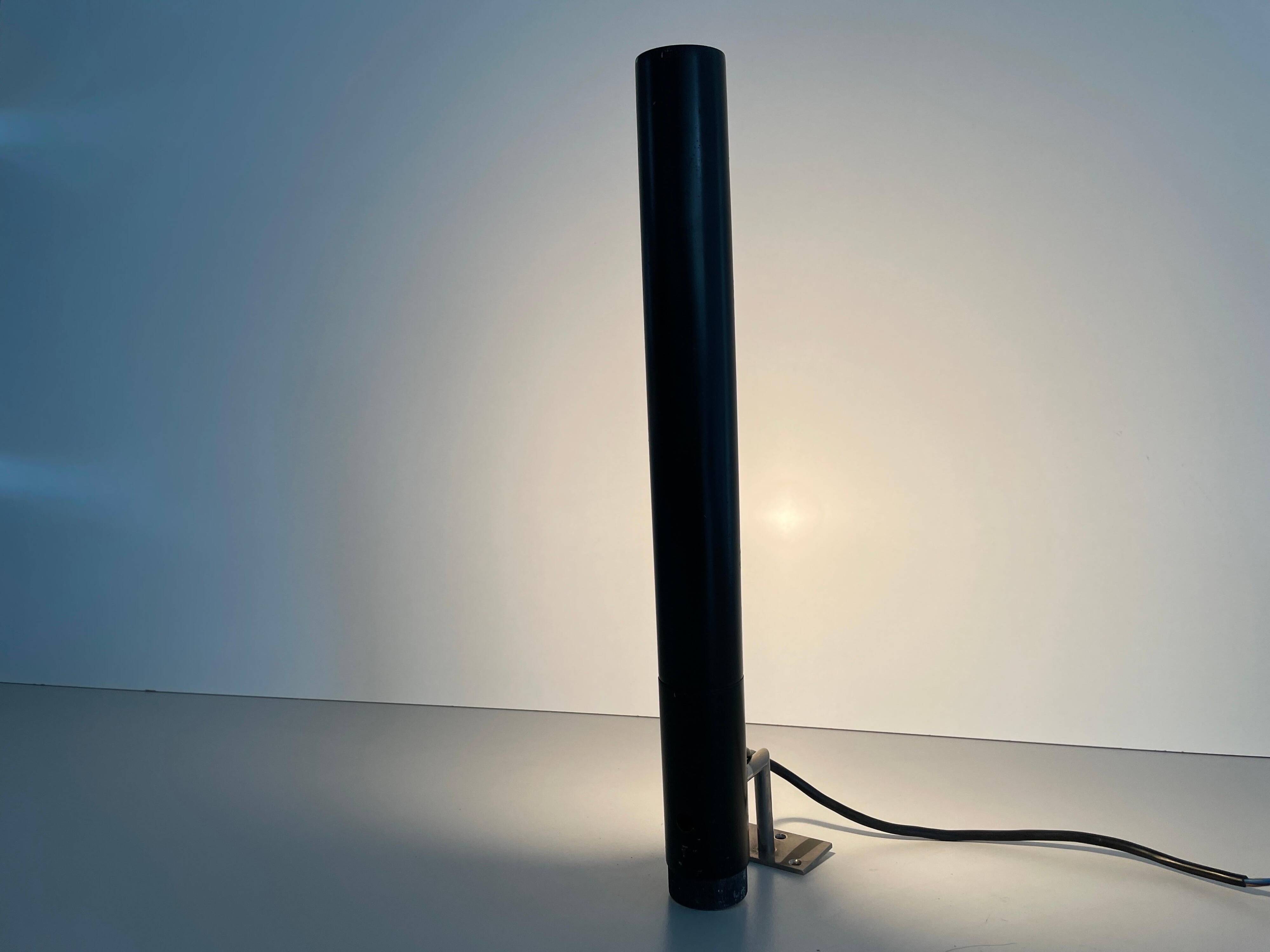 Minimalist black metal wall light with a cylindrical design, 1960s, Germany.