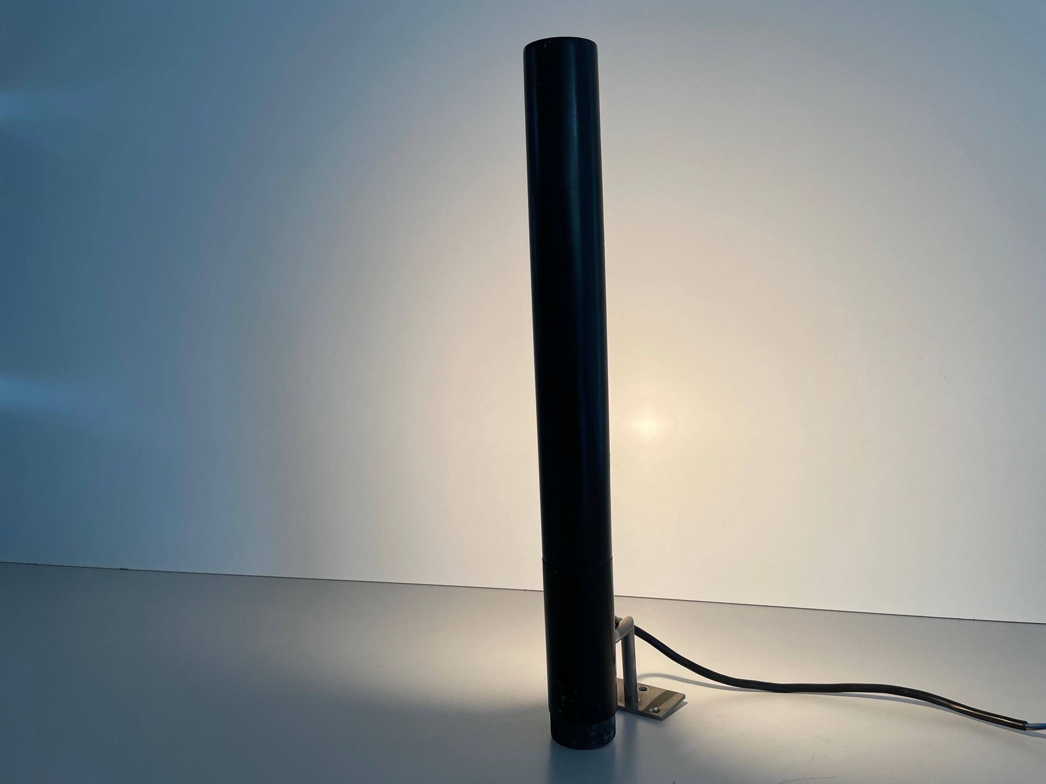 Minimalist black metal wall light with a cylindrical design, 1960s, Germany.