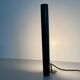Minimalist black metal wall light with a cylindrical design, 1960s, Germany.