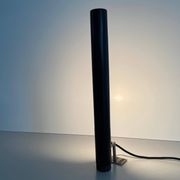 Minimalist black metal wall light with a cylindrical design, 1960s, Germany.