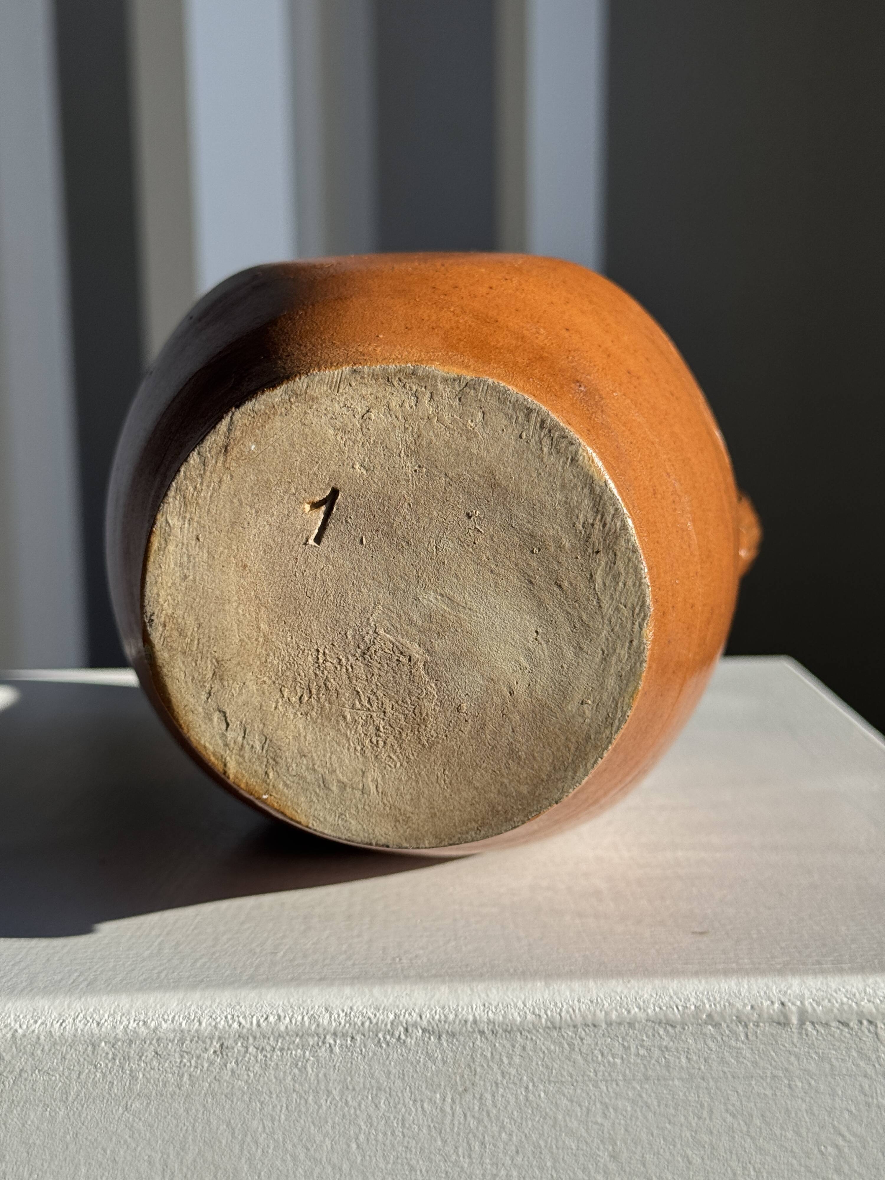 Ancient stoneware jug with a pewter spout.