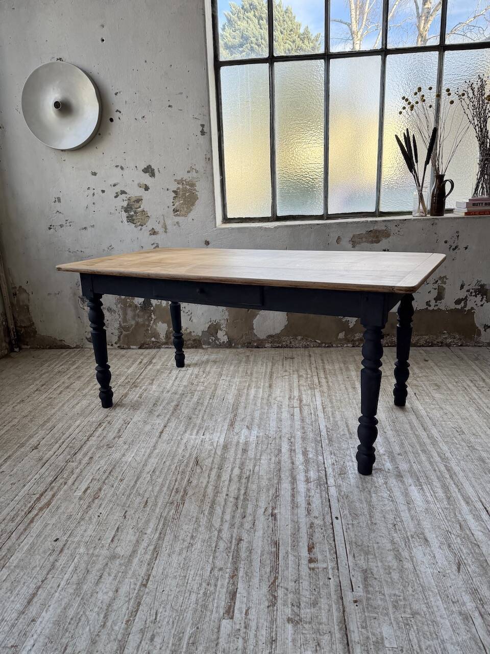 Oak farmhouse table with turned black legs.