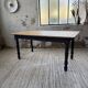 Oak farmhouse table with turned black legs.