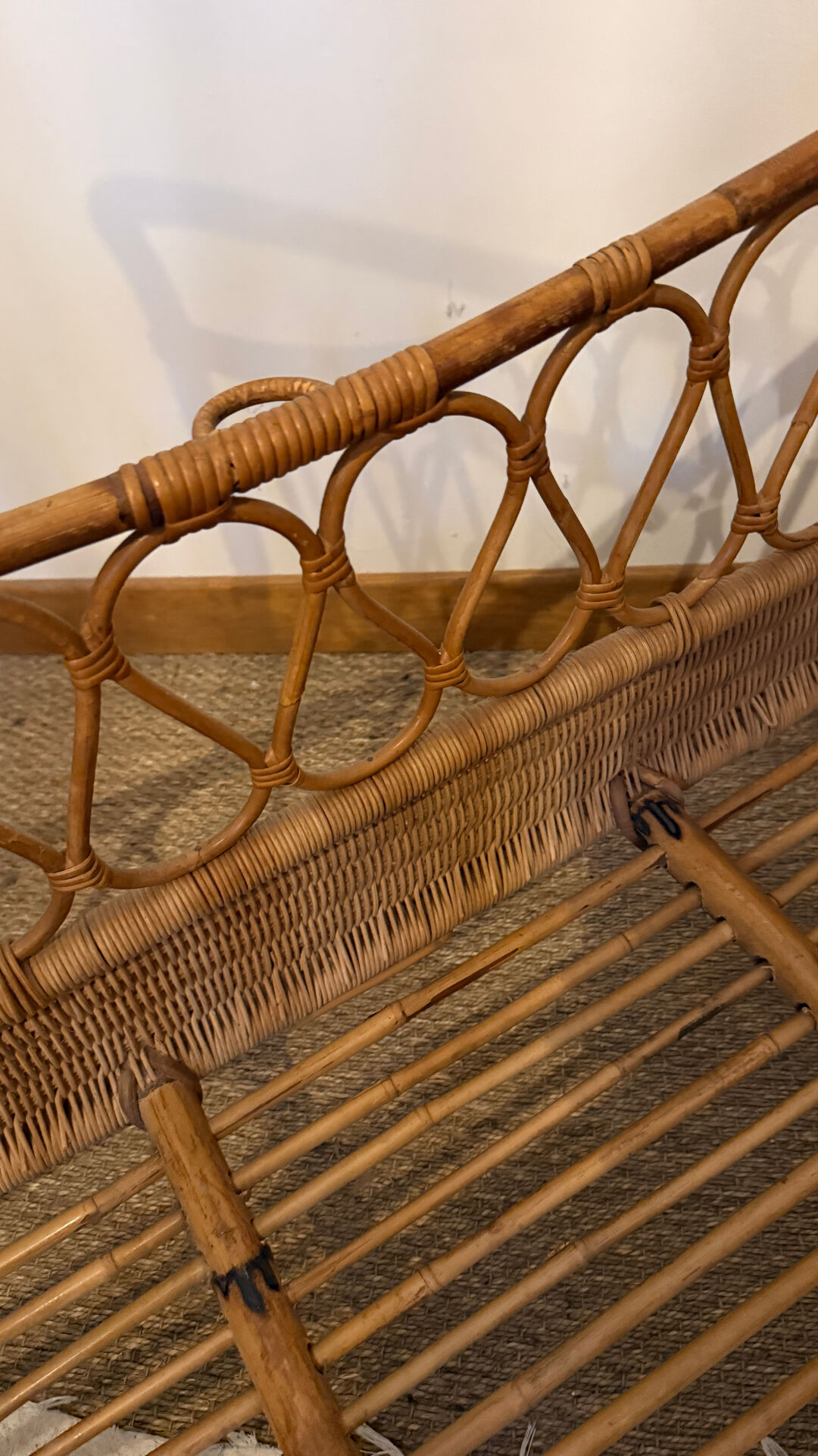 Vintage rattan baby cot on wheels.