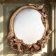 Oval wall mirror in Art Nouveau style with a decoration of birds and roses.