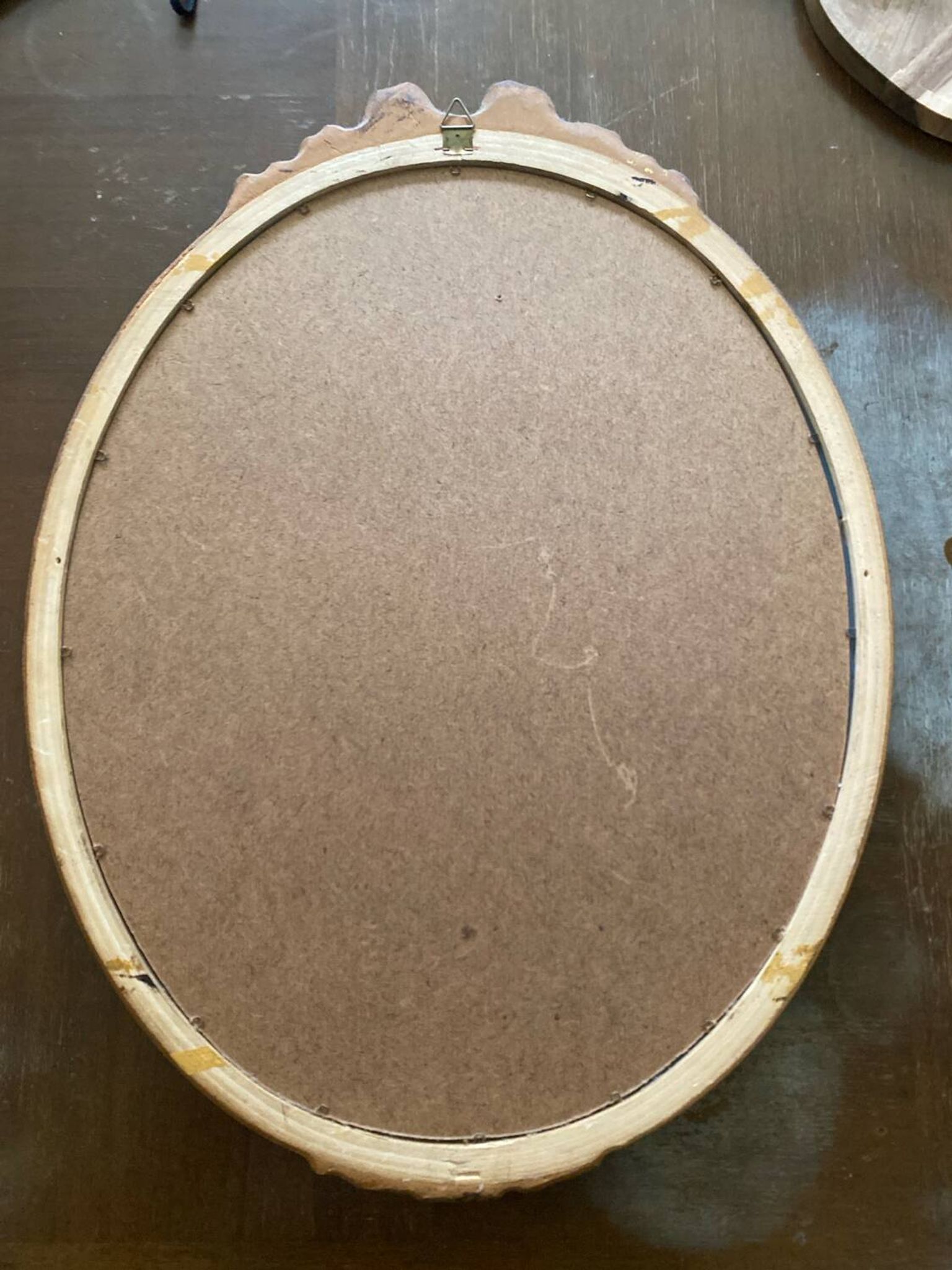 Antique oval mirror in Louis XVI style, gilded, with a bow pediment, 55cm.
