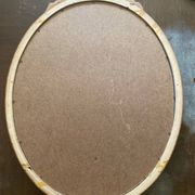 Antique oval mirror in Louis XVI style, gilded, with a bow pediment, 55cm.