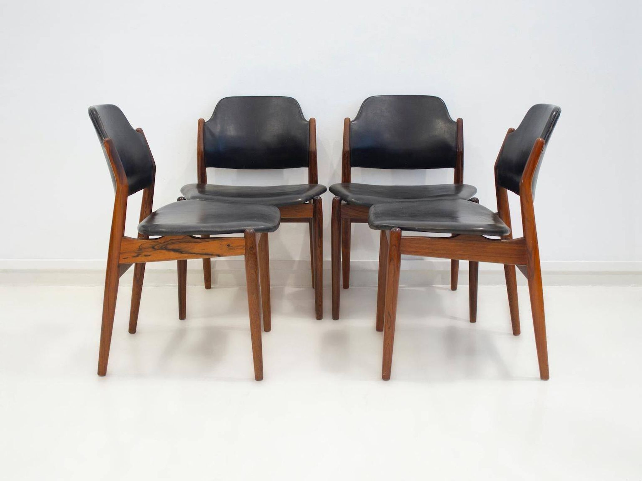 Set of four Arne Vodder chairs in hardwood and black leather.