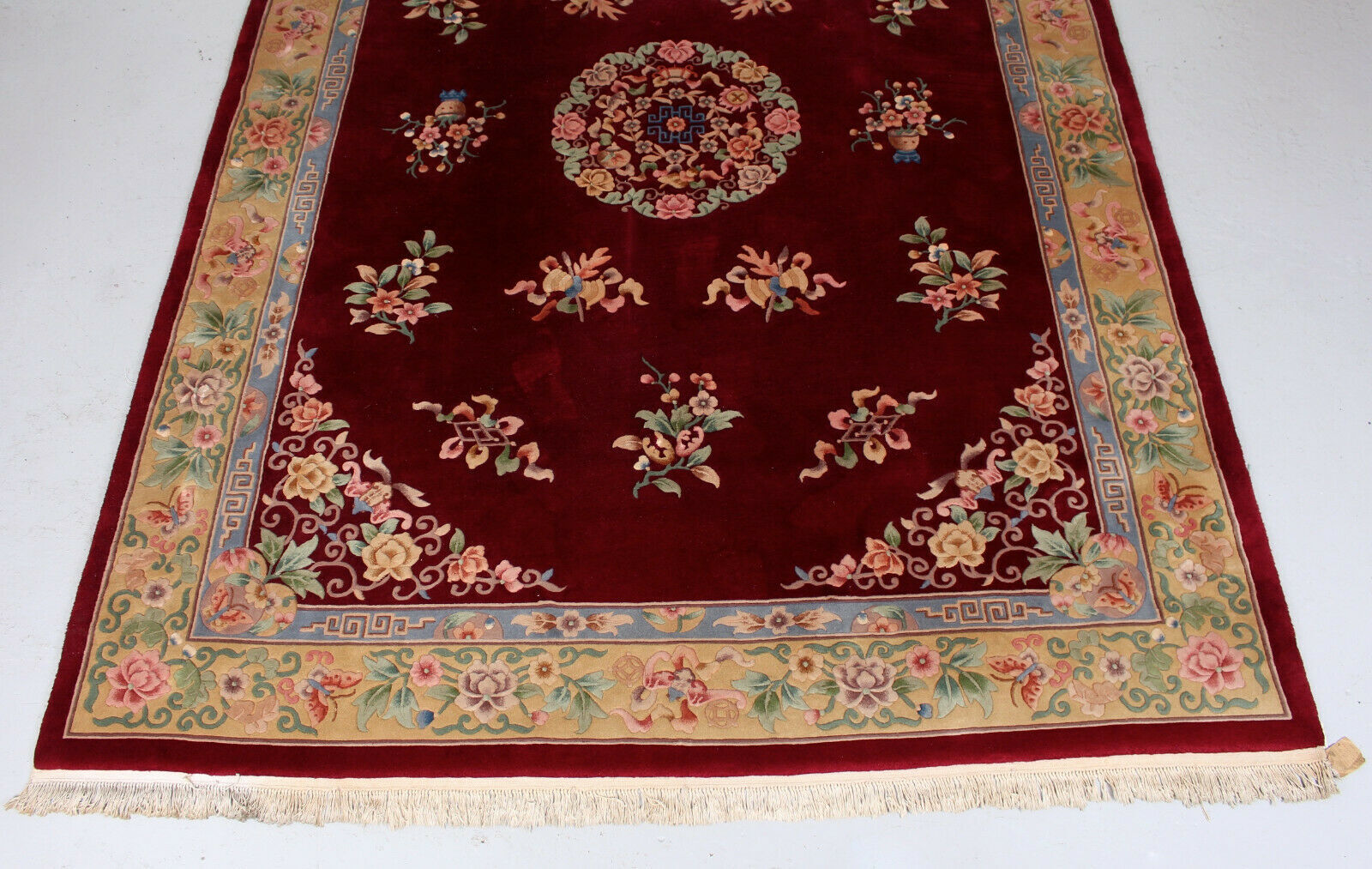 China wool fringed rug with floral pattern on deep plum background 393x274cm
