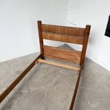 Brutalist style bed with chain and straw