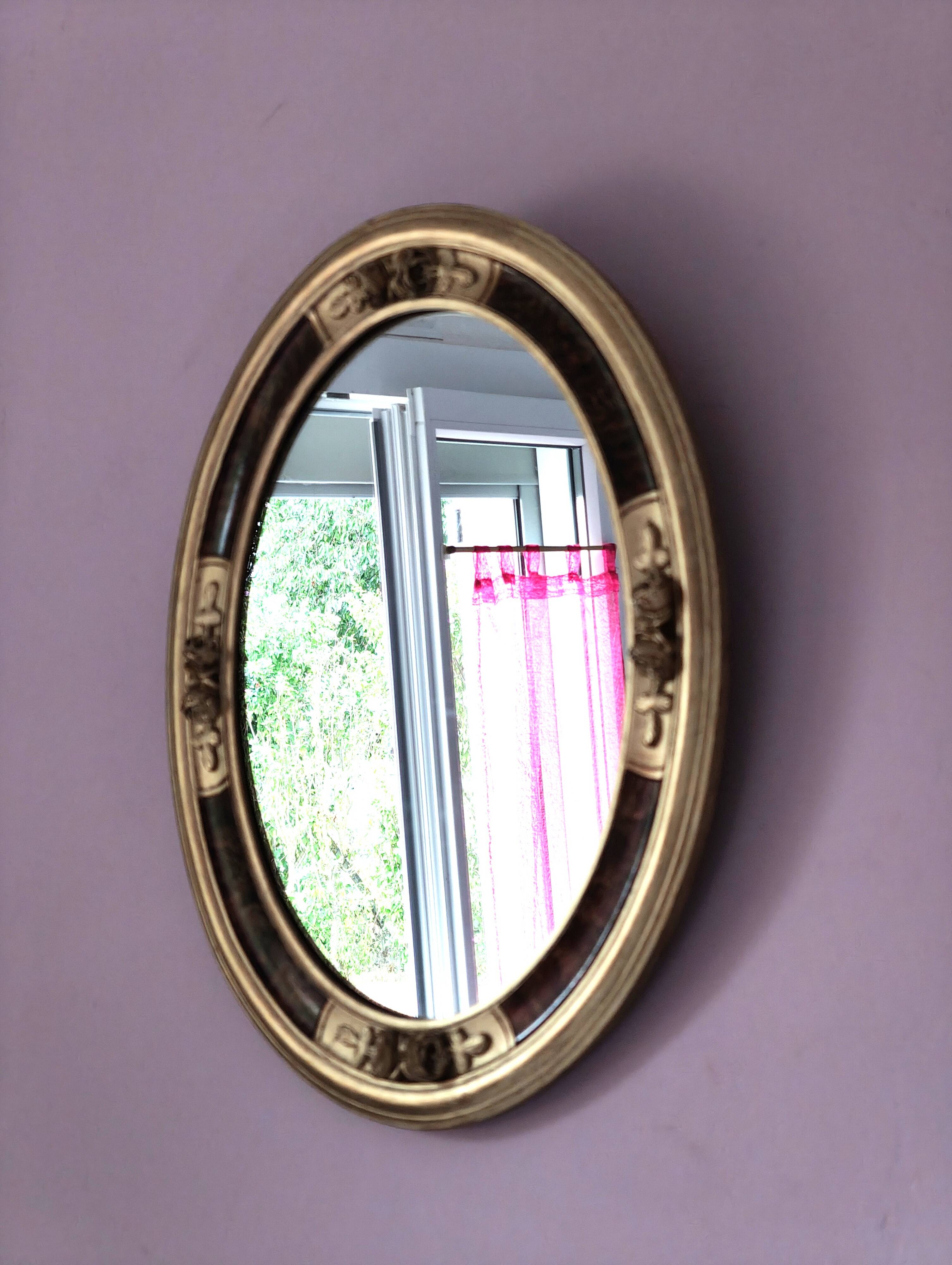Antique medallion mirror with a gilded and relief-carved frame.