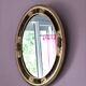 Antique medallion mirror with a gilded and relief-carved frame.