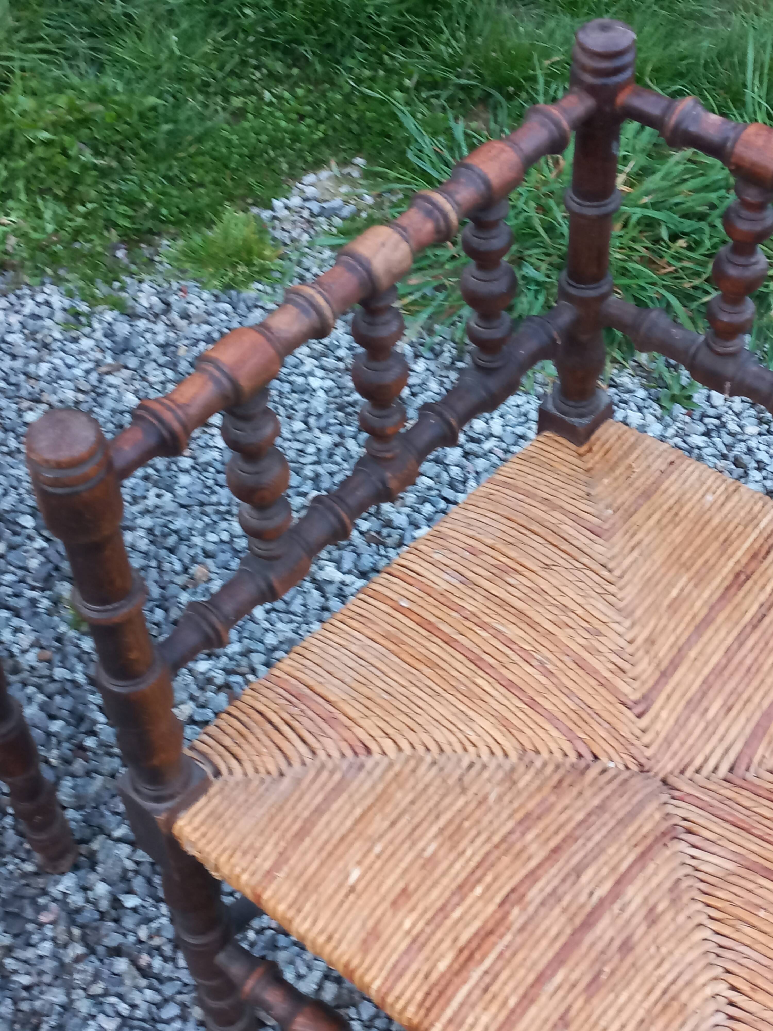 Pair of angled armchairs with turned wood and rush seats from the 1960s.