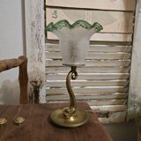 Small table lamp with a brass fish base and a tulip shade with green edges.