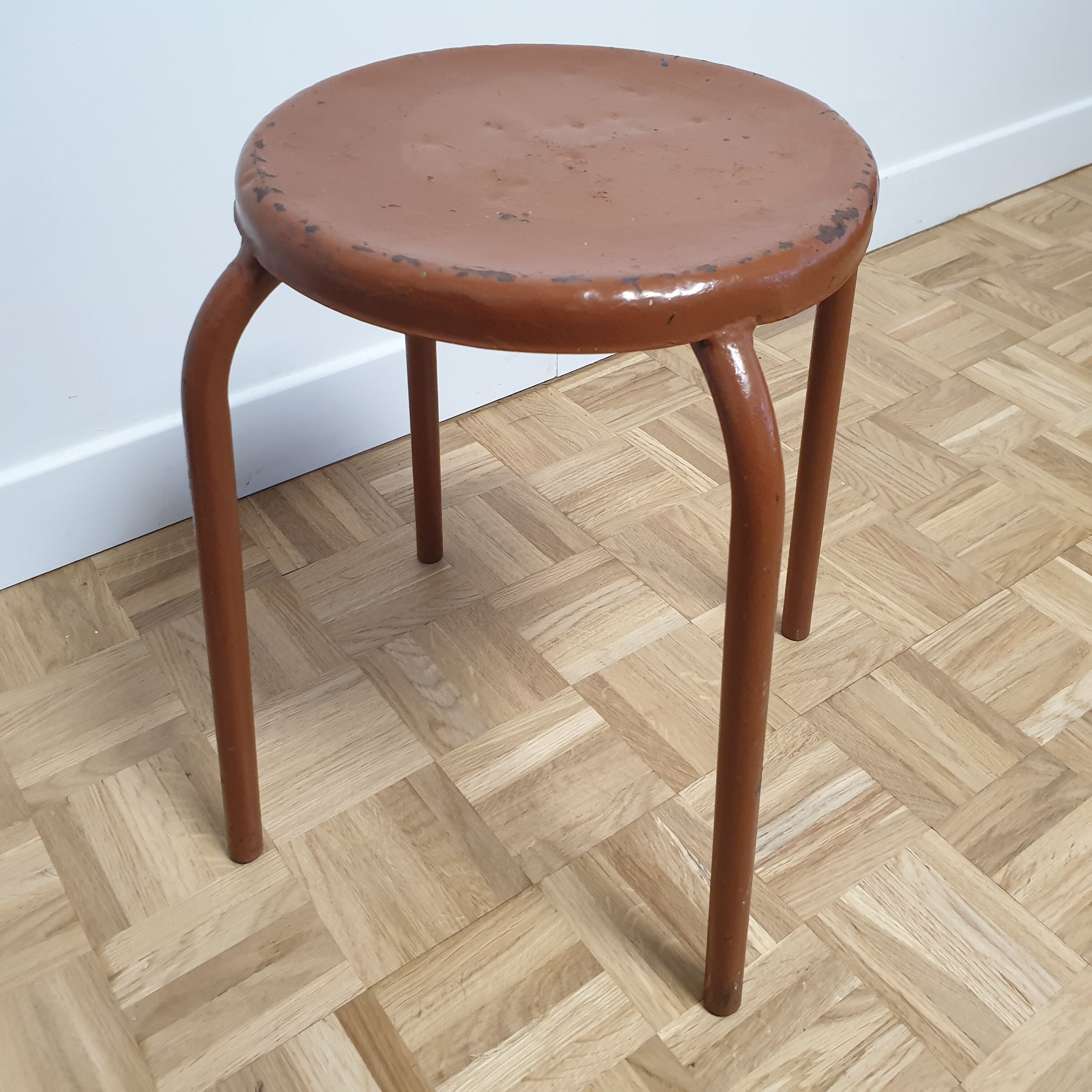 Rust-colored painted metal stool