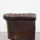 Cowhide English Chesterfield armchair with ball legs and timeless finish