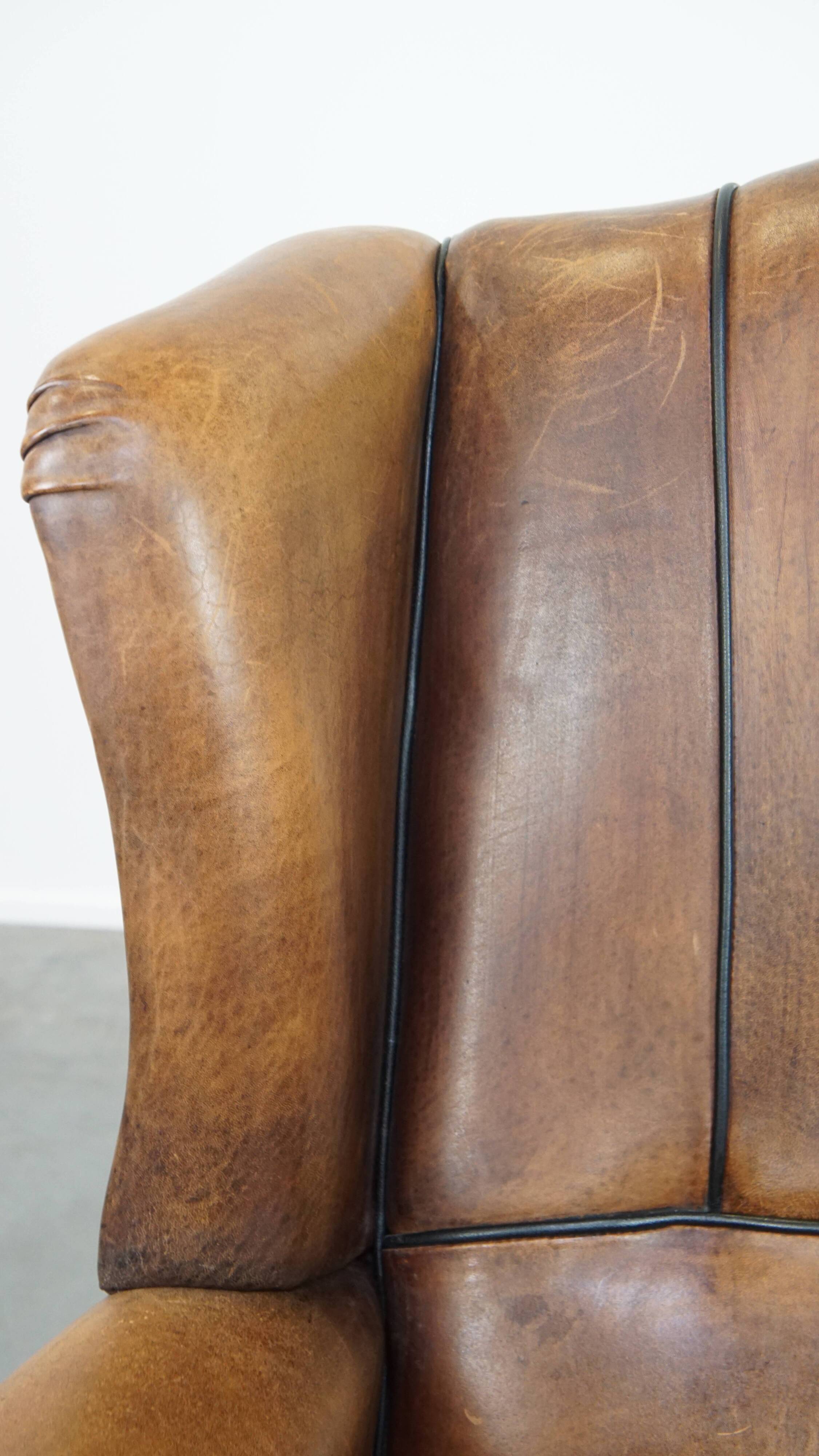 Sheep leather wingback chair finished with black piping