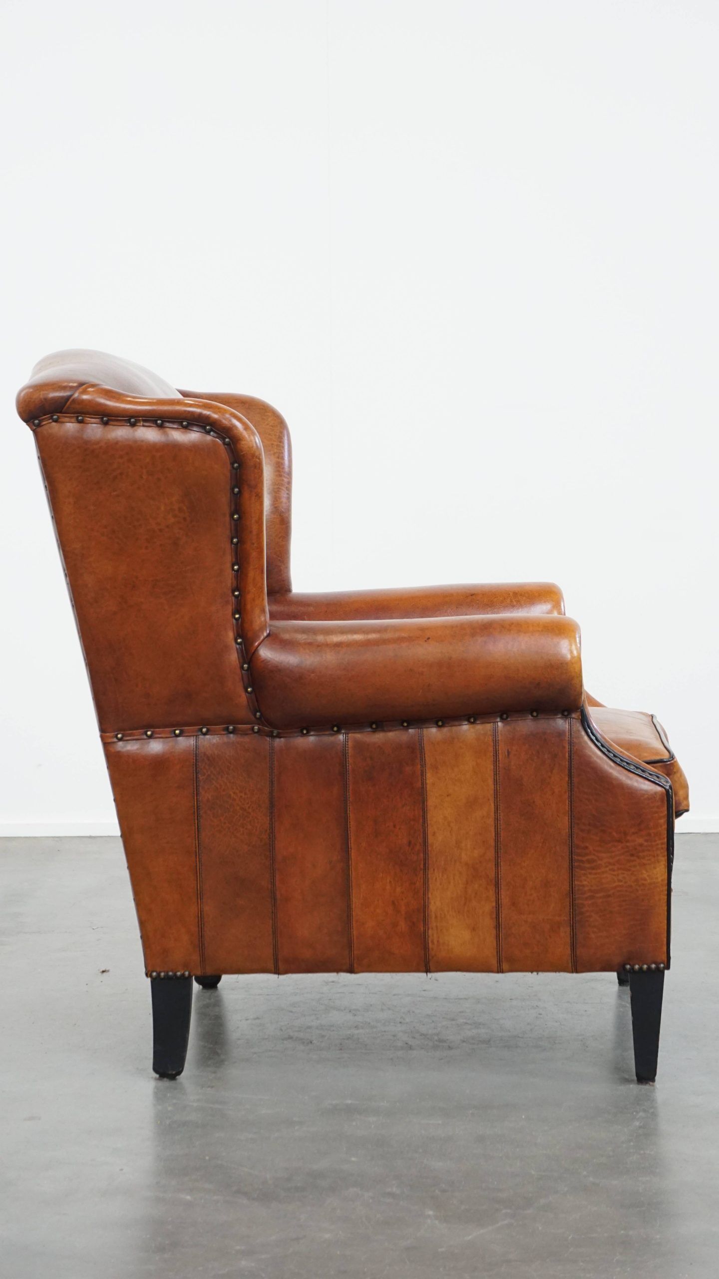 Sheepskin wingback armchair with stitching and black piping