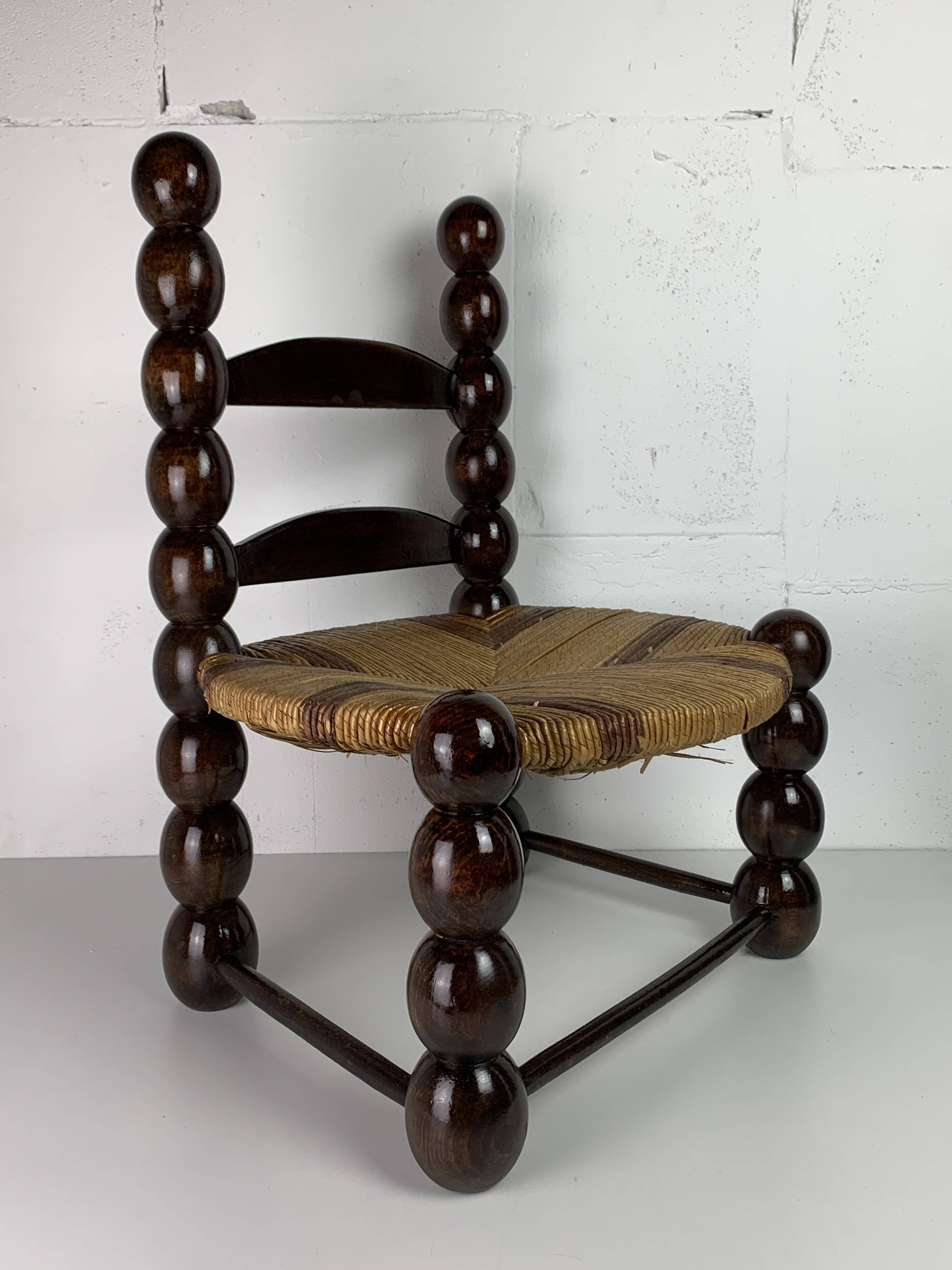Brutalist wood turned bobbin low rush chair n the style of Charles Dudouyt