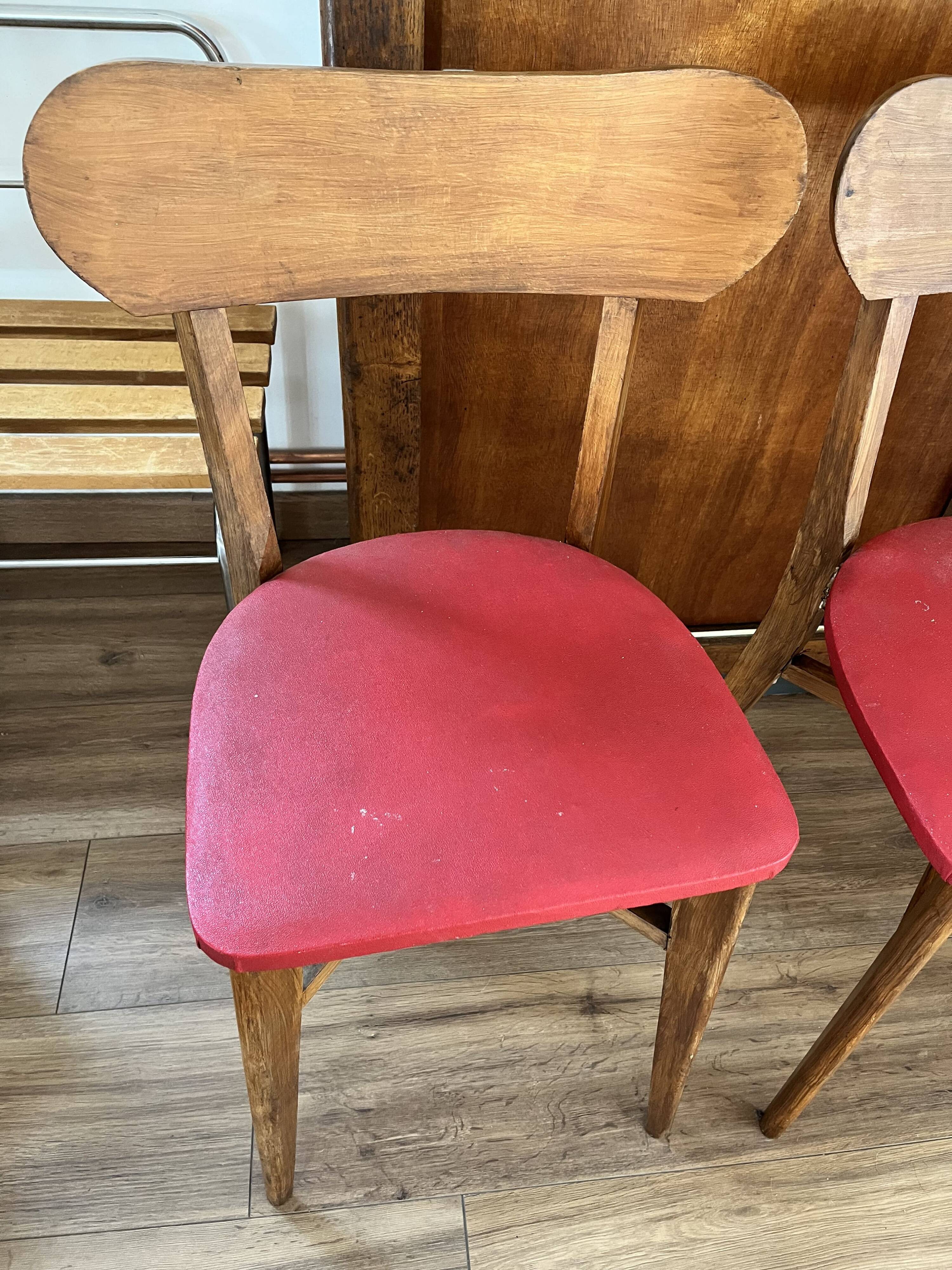 Set of 4 wooden chairs with red vinyl.
